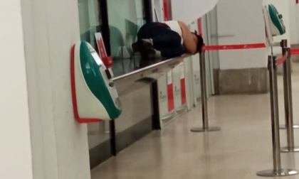 Stazione: uomo dorme sul bancone della biglietteria